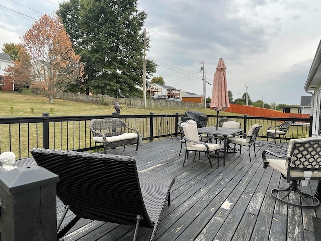 wooden terrace featuring a lawn