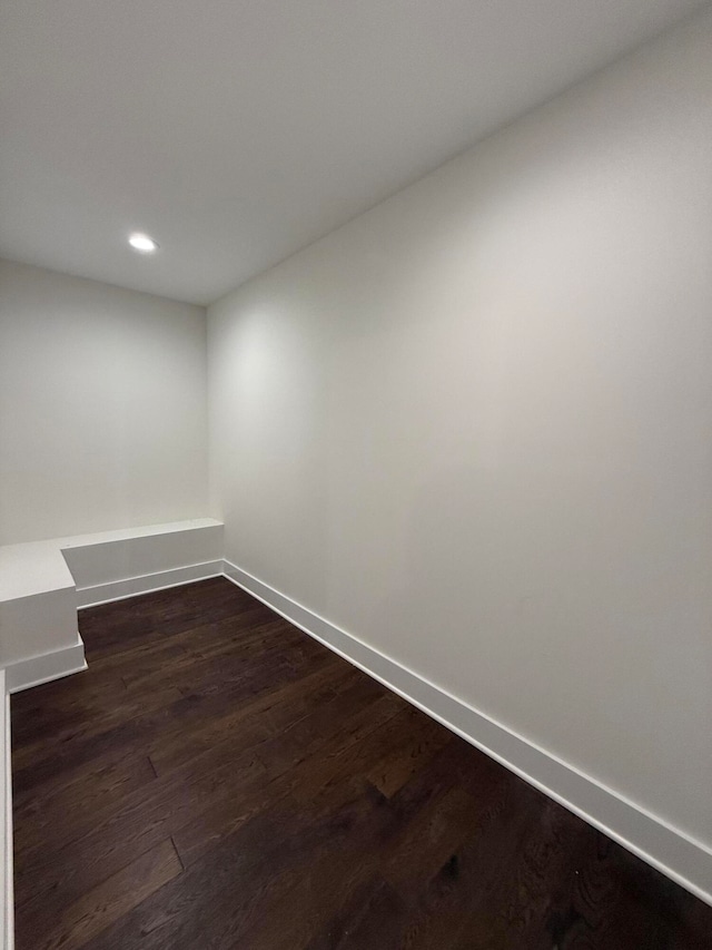 unfurnished room with dark wood finished floors, recessed lighting, and baseboards