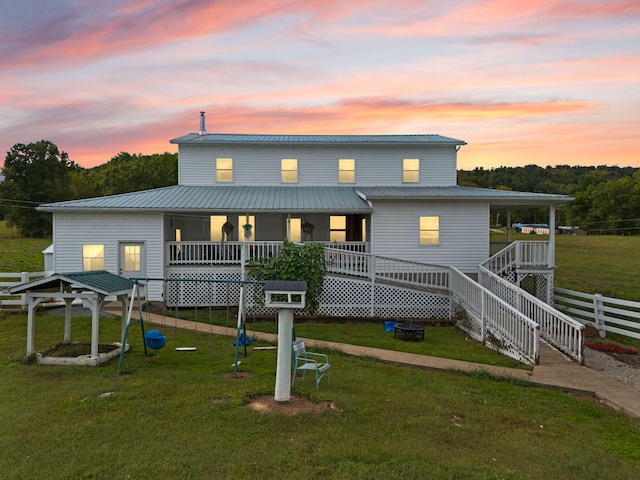 view of front of house with a wooden deck and a lawn