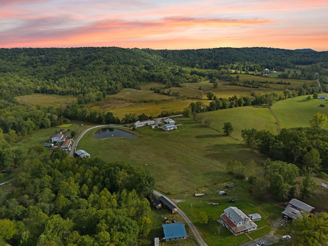 aerial view at dusk featuring a water view