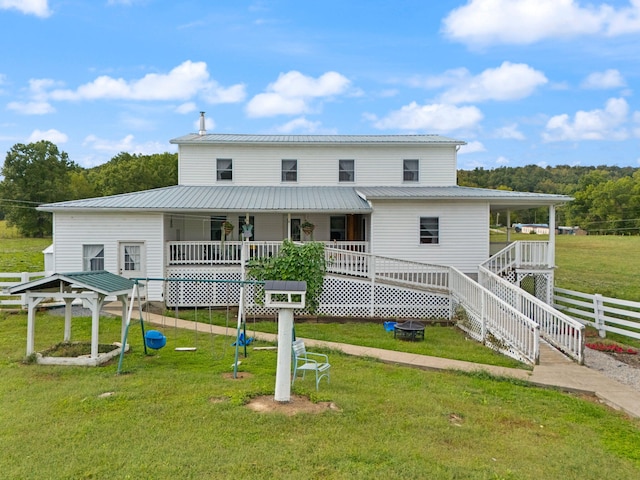 rear view of house featuring a yard and a porch