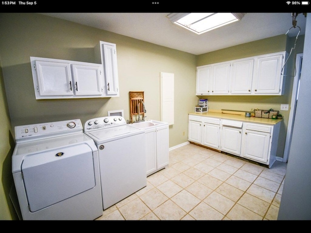 laundry area featuring washing machine and dryer, light tile patterned flooring, sink, and cabinets