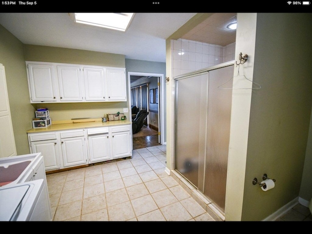 interior space with tile patterned flooring, a shower with door, and vanity