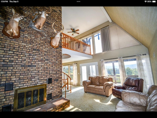 living room featuring high vaulted ceiling, a brick fireplace, and a wealth of natural light