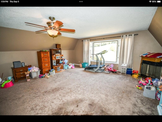 playroom featuring a textured ceiling, carpet, lofted ceiling, and ceiling fan