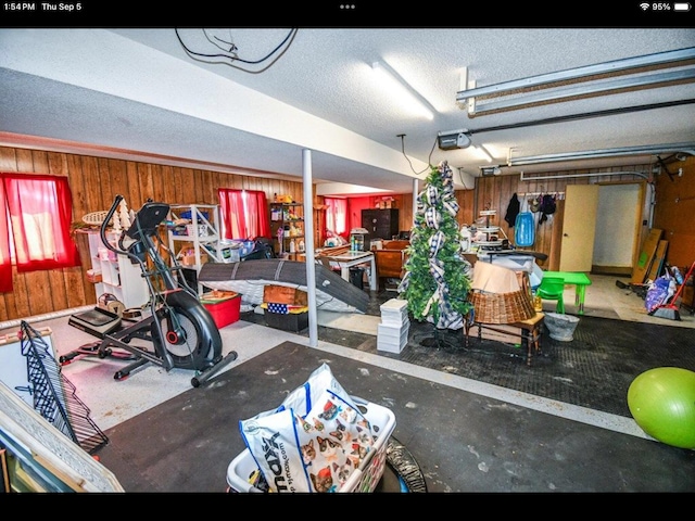 garage featuring a garage door opener and wooden walls