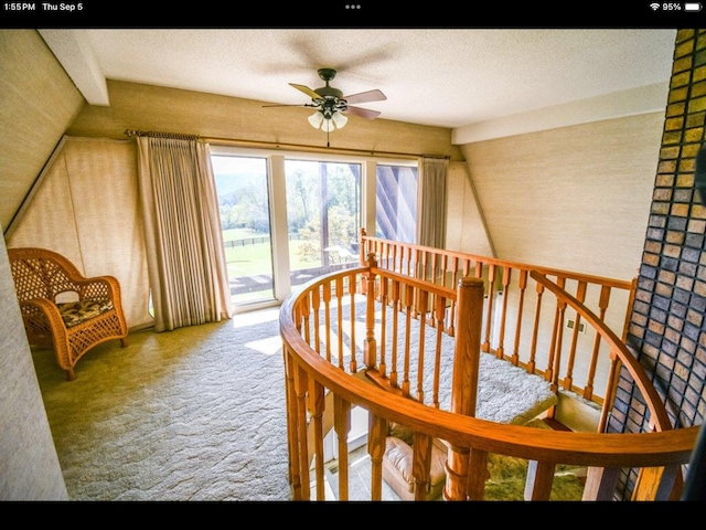 interior space with a textured ceiling, carpet floors, and ceiling fan