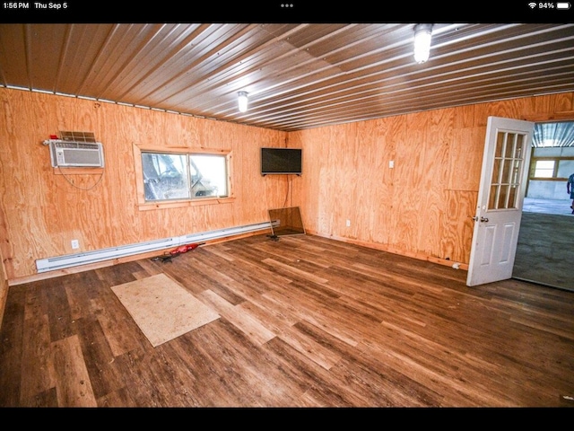 unfurnished room with wood ceiling, a baseboard heating unit, dark wood-type flooring, wooden walls, and a wall mounted air conditioner