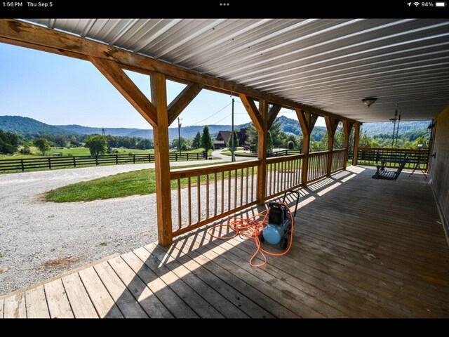 wooden deck with a mountain view, a rural view, and a yard