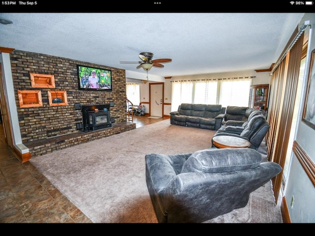 living room featuring a wood stove, a textured ceiling, and ceiling fan