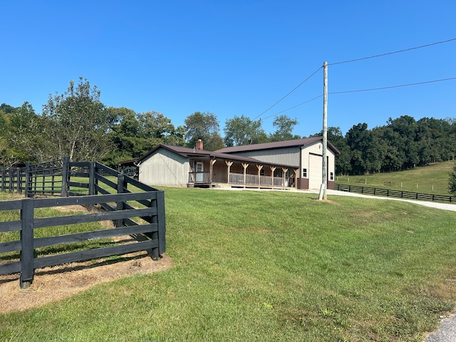 view of front of home with a front lawn, an outdoor structure, and a rural view