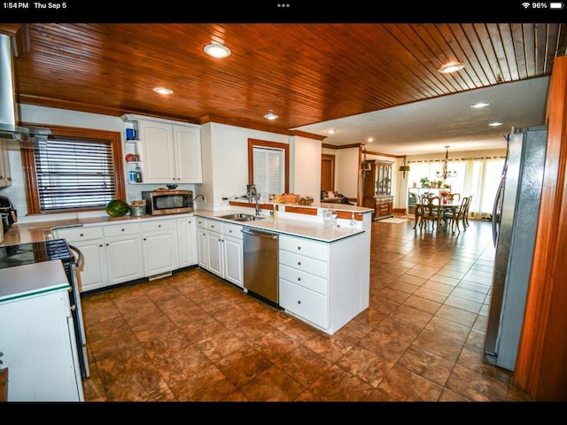 kitchen with white cabinets, appliances with stainless steel finishes, kitchen peninsula, and a healthy amount of sunlight