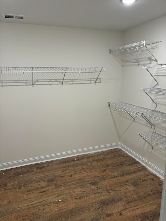 spacious closet with dark hardwood / wood-style floors