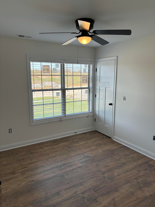 spare room with dark hardwood / wood-style floors, plenty of natural light, and ceiling fan