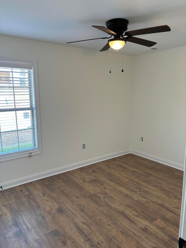 spare room featuring dark wood-type flooring and ceiling fan