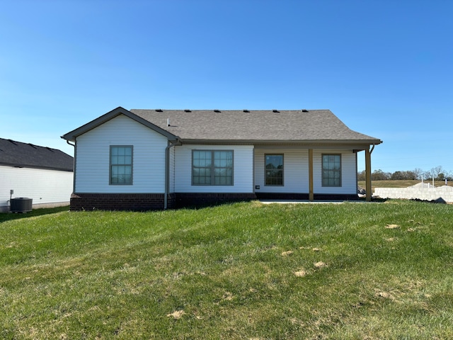 back of house with central AC and a yard