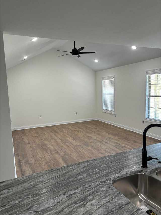 interior space featuring sink, ceiling fan, hardwood / wood-style flooring, and lofted ceiling