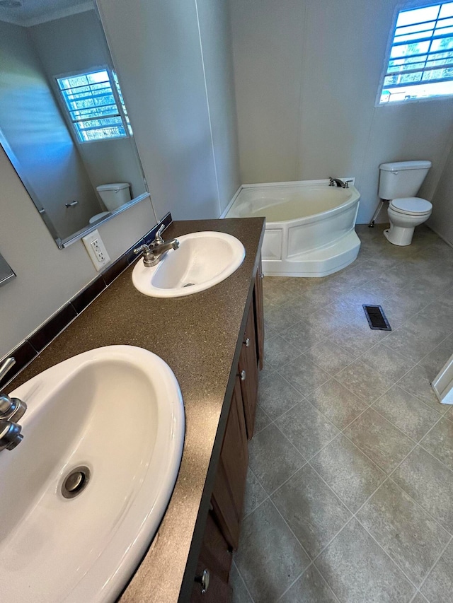 bathroom with vanity, tile patterned flooring, toilet, and a bathing tub