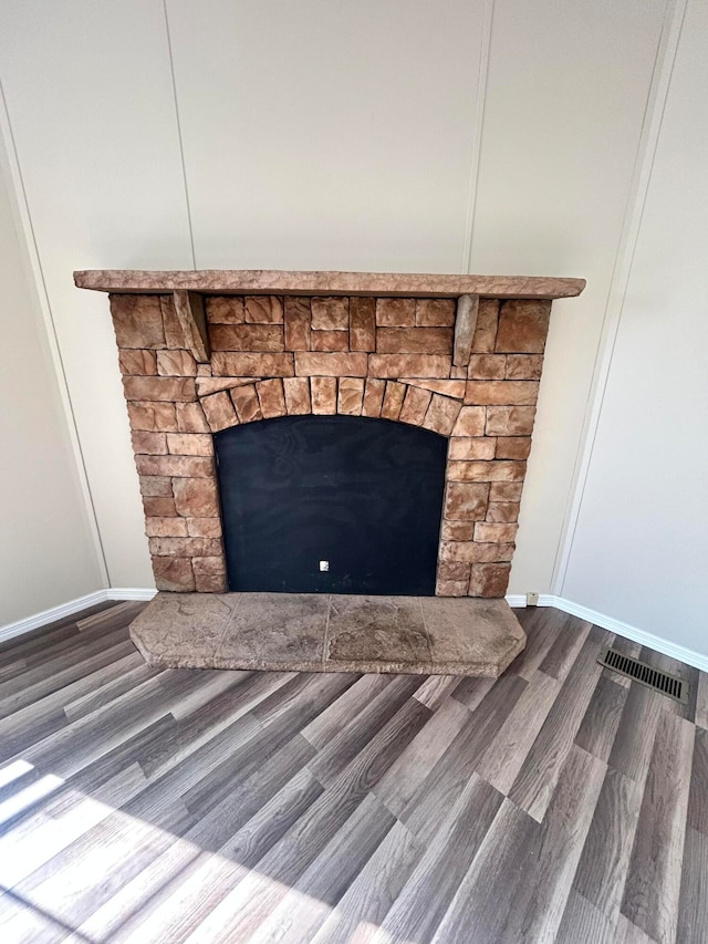 details with a stone fireplace and hardwood / wood-style floors