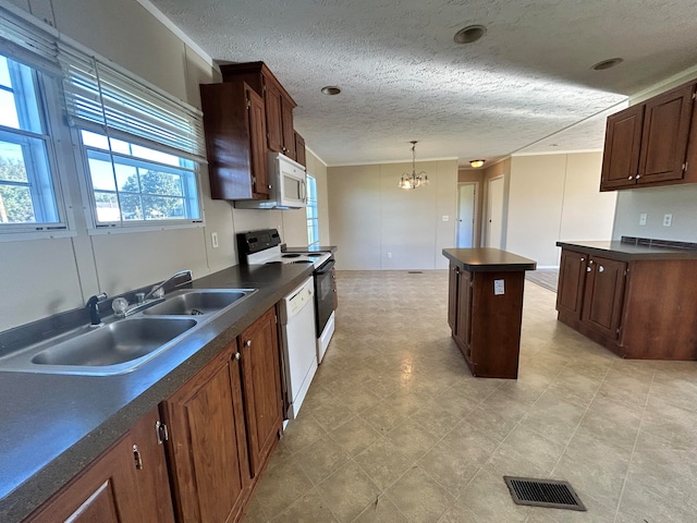 kitchen with a kitchen island, an inviting chandelier, pendant lighting, sink, and white appliances