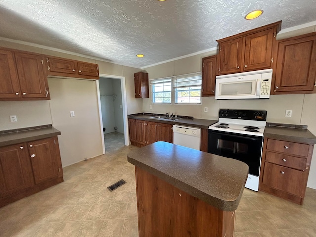 kitchen with white appliances, sink, a kitchen island, a textured ceiling, and crown molding