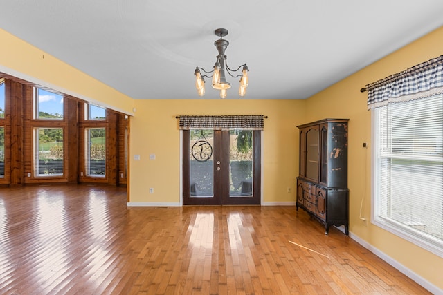 foyer entrance featuring a chandelier, light wood-type flooring, and french doors