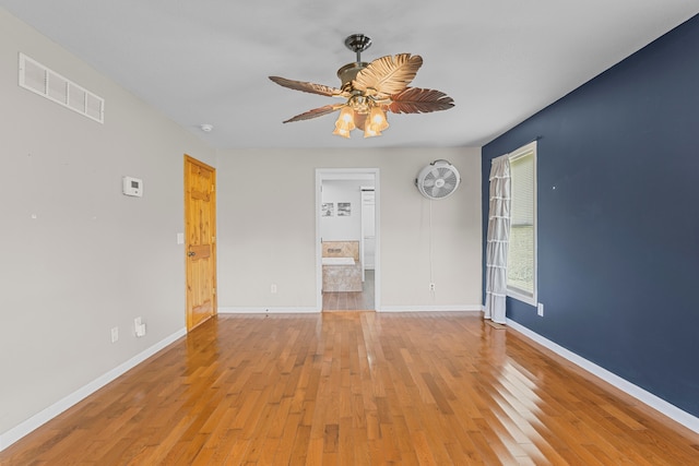 empty room with ceiling fan and light hardwood / wood-style floors