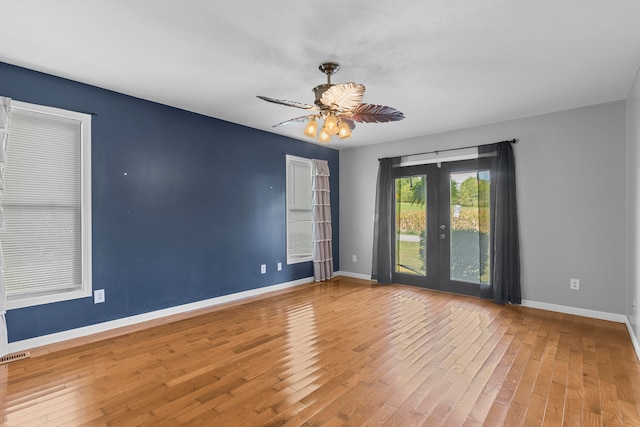 empty room with french doors, ceiling fan, and hardwood / wood-style floors