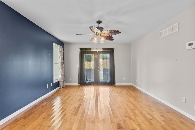 spare room featuring french doors, light wood-type flooring, and ceiling fan