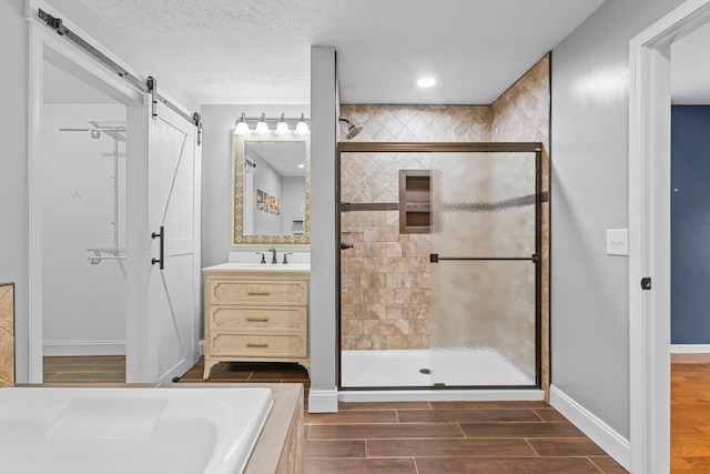 bathroom featuring vanity, a textured ceiling, independent shower and bath, and wood-type flooring