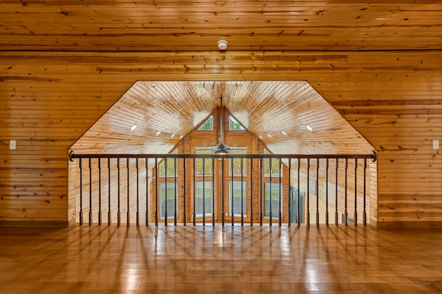 additional living space with ceiling fan, wood walls, wooden ceiling, and hardwood / wood-style floors