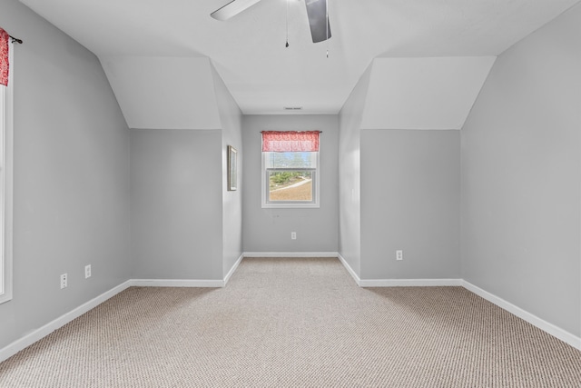 additional living space featuring light carpet, lofted ceiling, and ceiling fan