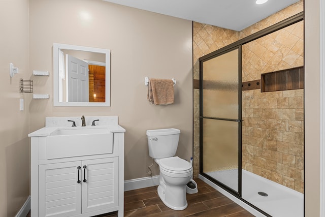 bathroom featuring toilet, walk in shower, vanity, and hardwood / wood-style flooring