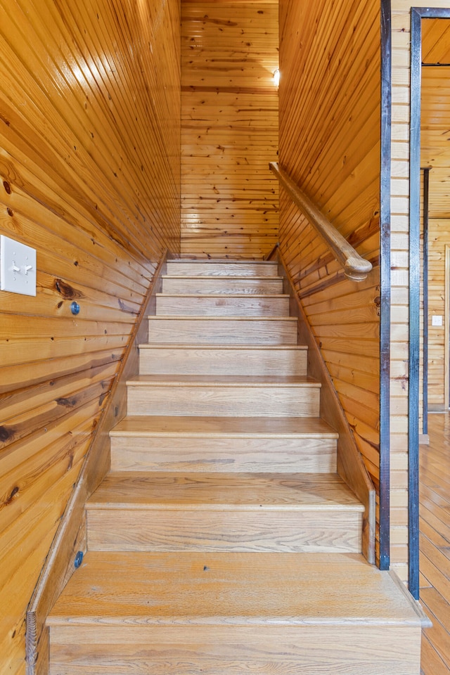 stairway with hardwood / wood-style flooring, wooden ceiling, and wood walls