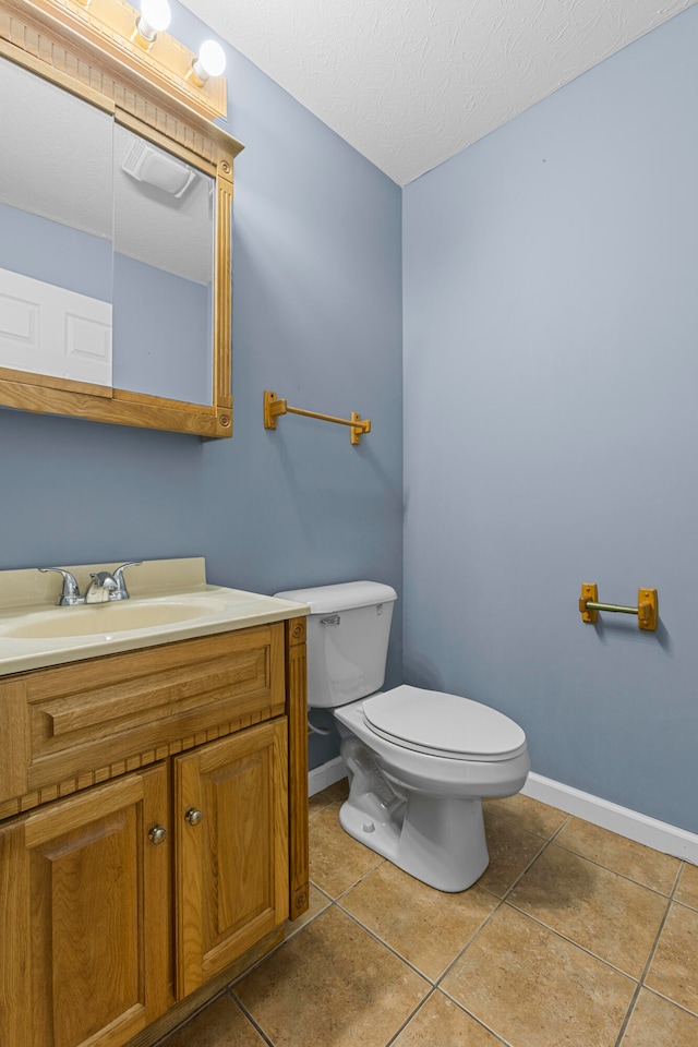 bathroom featuring vanity, toilet, tile patterned floors, and a textured ceiling