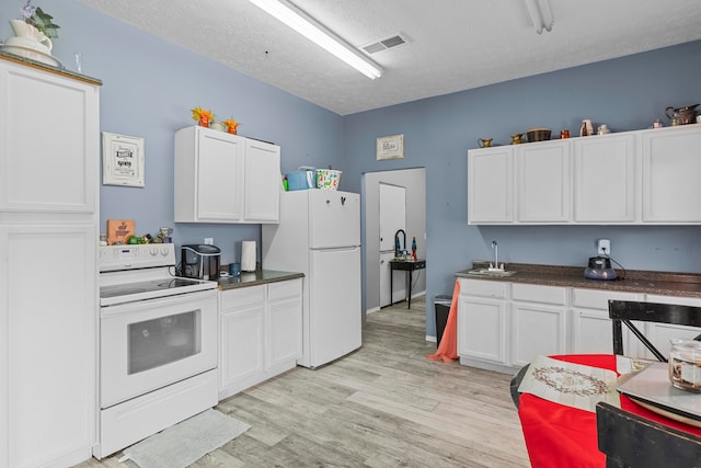 kitchen featuring white appliances, sink, a textured ceiling, light hardwood / wood-style floors, and white cabinets