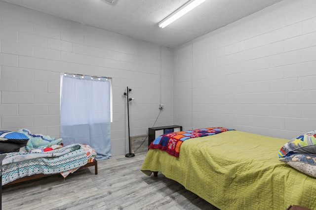 bedroom featuring light hardwood / wood-style flooring and a textured ceiling