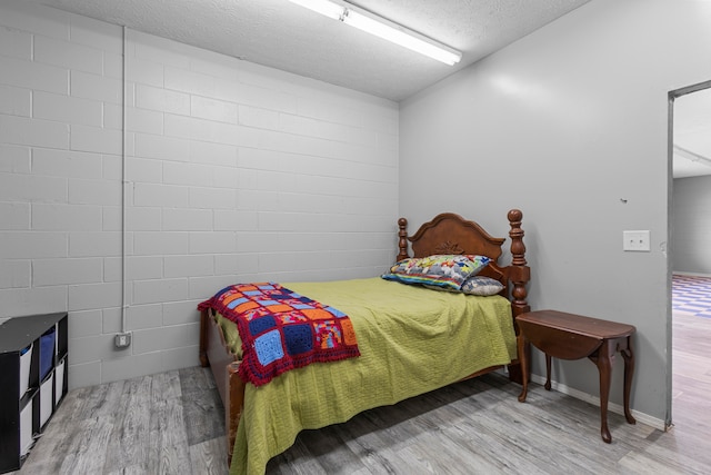 bedroom featuring a textured ceiling and wood-type flooring