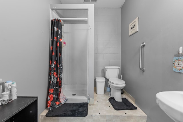 bathroom featuring toilet, sink, and curtained shower