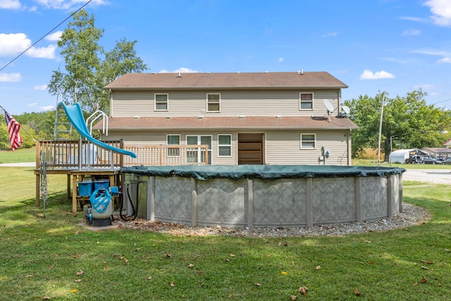 back of property with a covered pool and a lawn