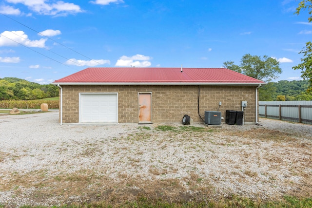 exterior space with central AC unit and a garage