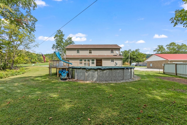 back of house featuring a covered pool and a lawn