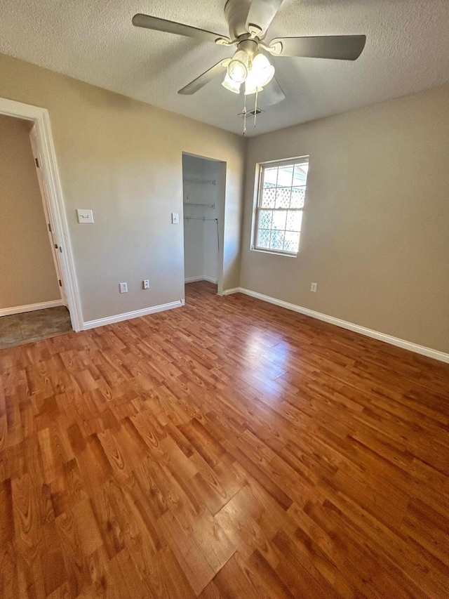 unfurnished bedroom featuring ceiling fan, hardwood / wood-style floors, and a textured ceiling