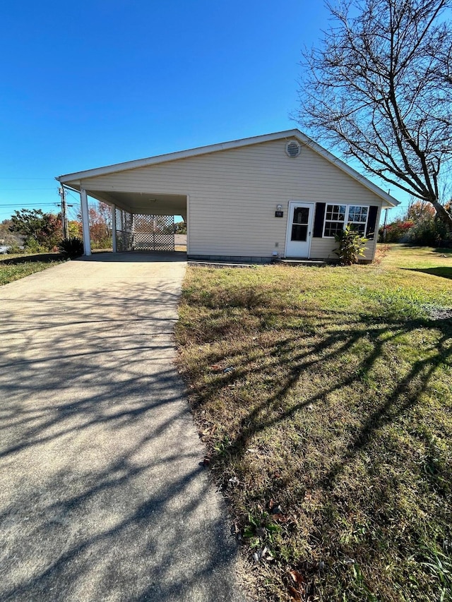 view of side of property with a lawn and a carport