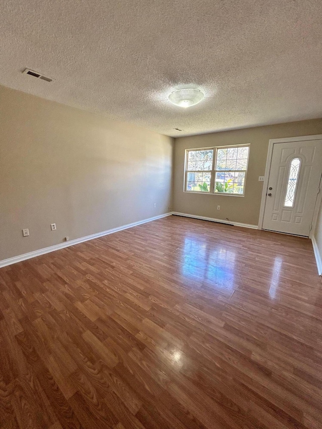 interior space with wood-type flooring and a textured ceiling