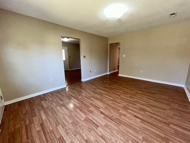 spare room featuring wood-type flooring and a textured ceiling