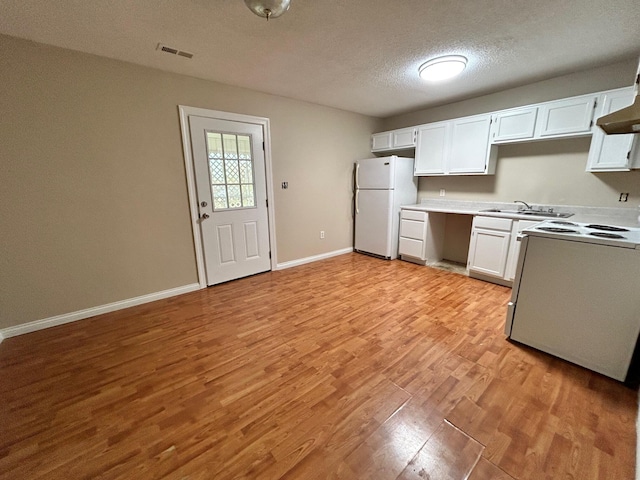 kitchen with white cabinetry, light hardwood / wood-style flooring, white refrigerator, a textured ceiling, and range