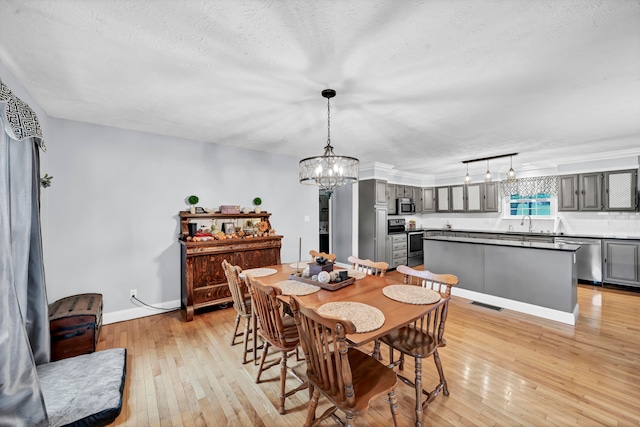 dining area with light hardwood / wood-style flooring, a textured ceiling, and sink