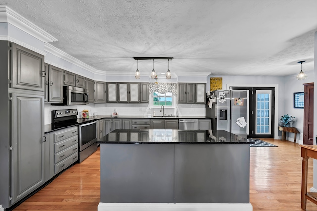 kitchen with gray cabinetry, light hardwood / wood-style flooring, stainless steel appliances, and a center island