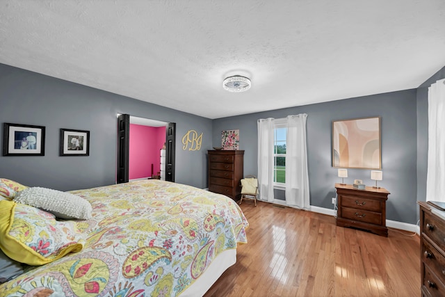 bedroom featuring light hardwood / wood-style flooring and a textured ceiling